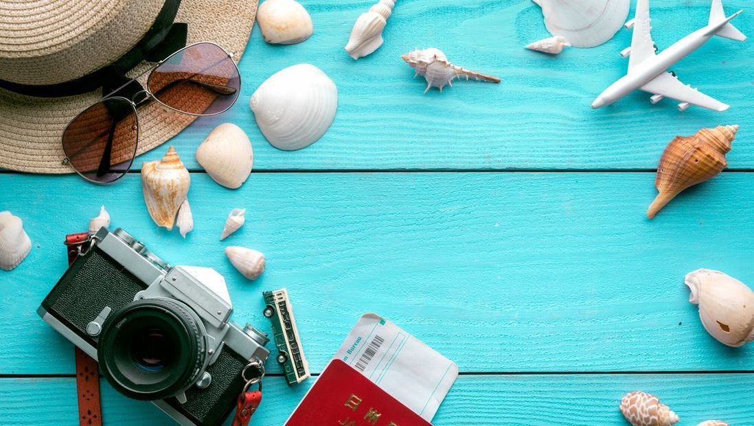 Blue wooden background with sea shells and travel related resources